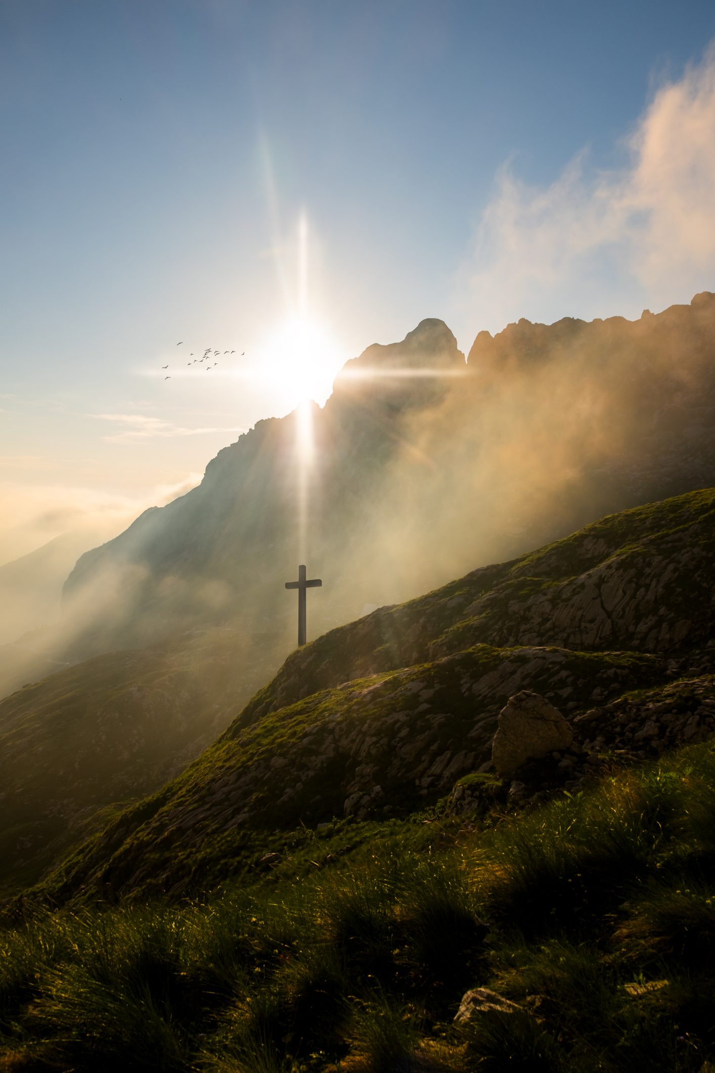 Mountain sunrise with cross silhouette