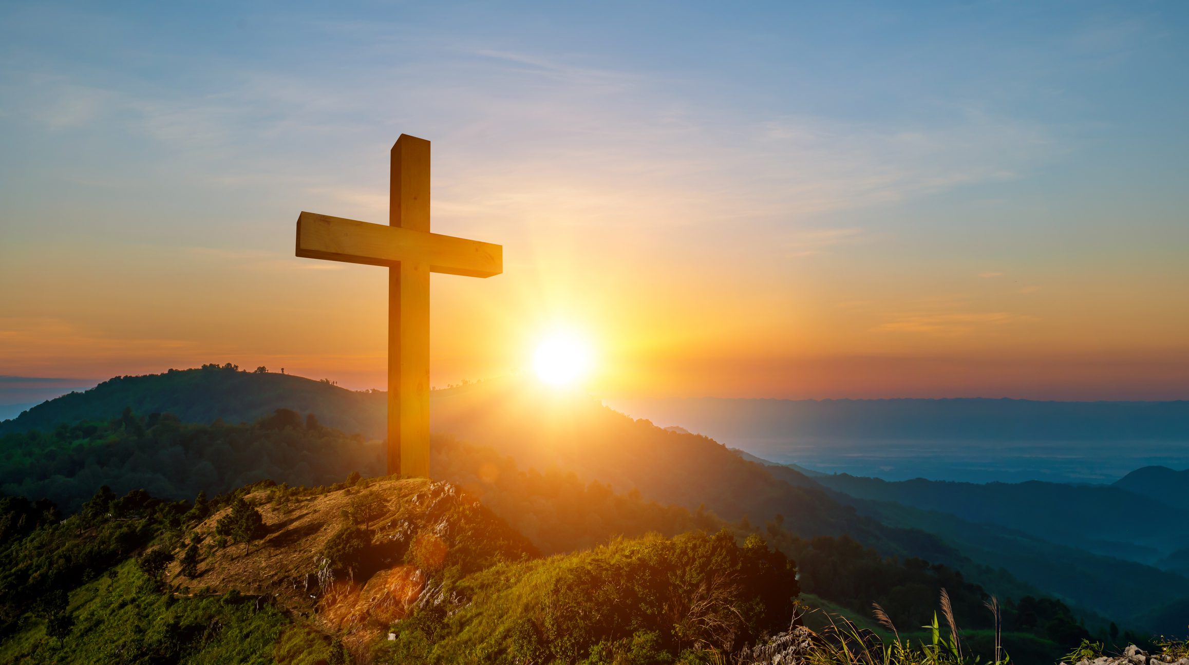 Cross overlooking sunrise on a mountain
