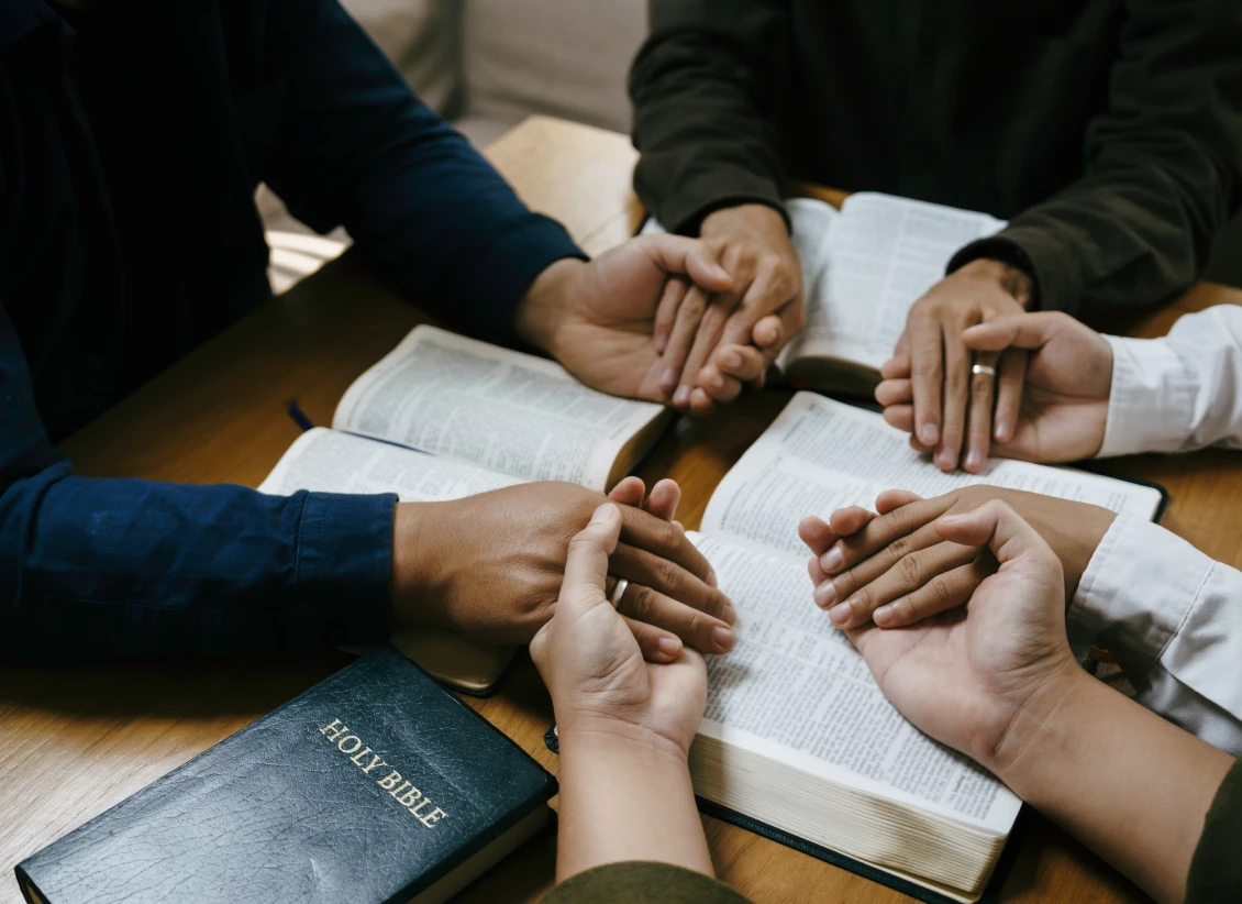 People holding hands in prayer circle