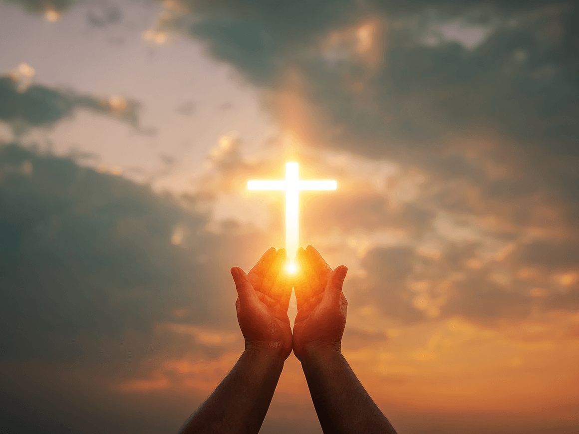 Silhouette of hands with bright cross